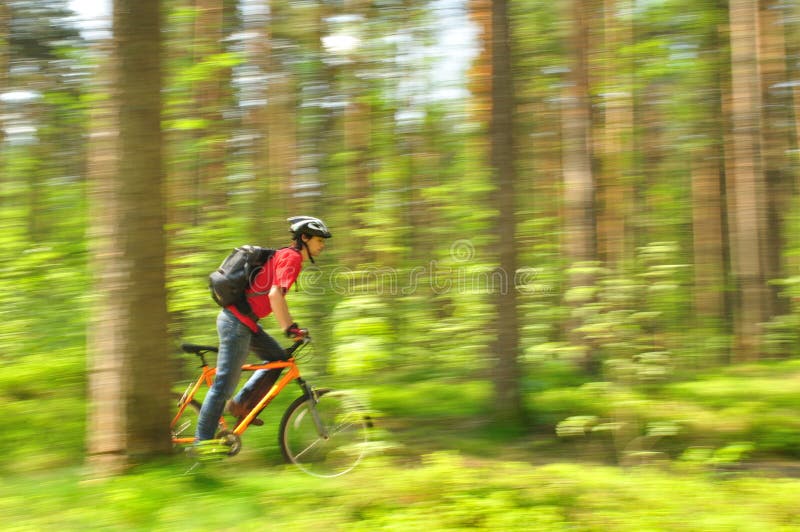 Сyclist, racing through the woods