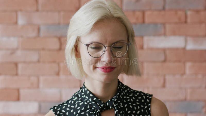 УлыбающаÑÑÑ Ð¶ÐµÐ½Ñ‰Ð¸Ð½Ð° в очках над кирпичной Ñтеной сток-видео