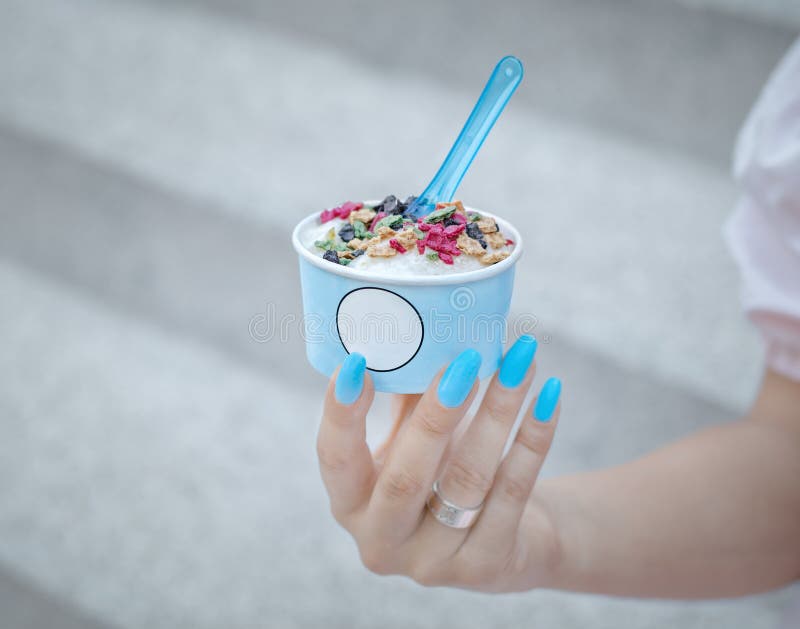Ветроуловители мороженого gelato удерживания девушки в голубой чашке с мякишами конуса стоковое изображение rf Ветроуловители мороженого gelato удерживания девушки в голубой чашке с мякишами конуса стоковое изображение rf