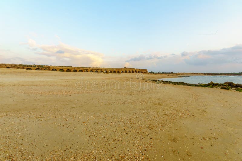 Взгляд захода солнца пляжа и римского акведука в Caesarea стоковая фотография Взгляд захода солнца пляжа и римского акведука в Caesarea стоковая фотография
