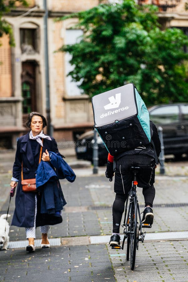 Вид сзади задействовать велосипедиста Deliveroo быстрый на французской улице стоковое фото Вид сзади задействовать велосипедиста Deliveroo быстрый на французской улице стоковое фото