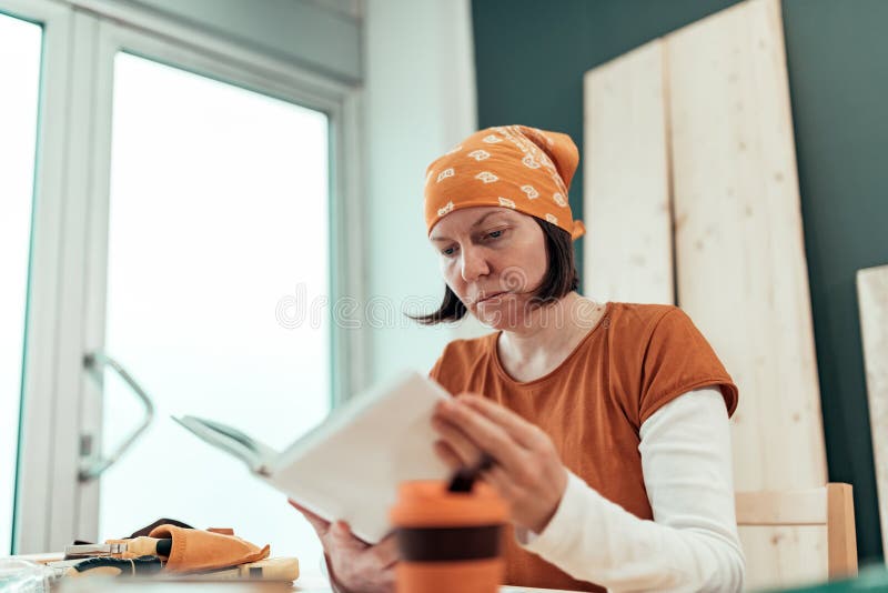 Женское руководство по эксплуатации проекта чтения DIY плотника стоковая фотография Женское руководство по эксплуатации проекта чтения DIY плотника стоковая фотография