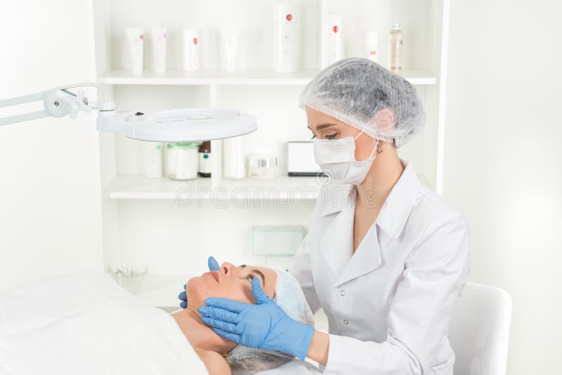 Женский доктор beautician с пациентом в центре здоровья E стоковое фото Женский доктор beautician с пациентом в центре здоровья E стоковое фото