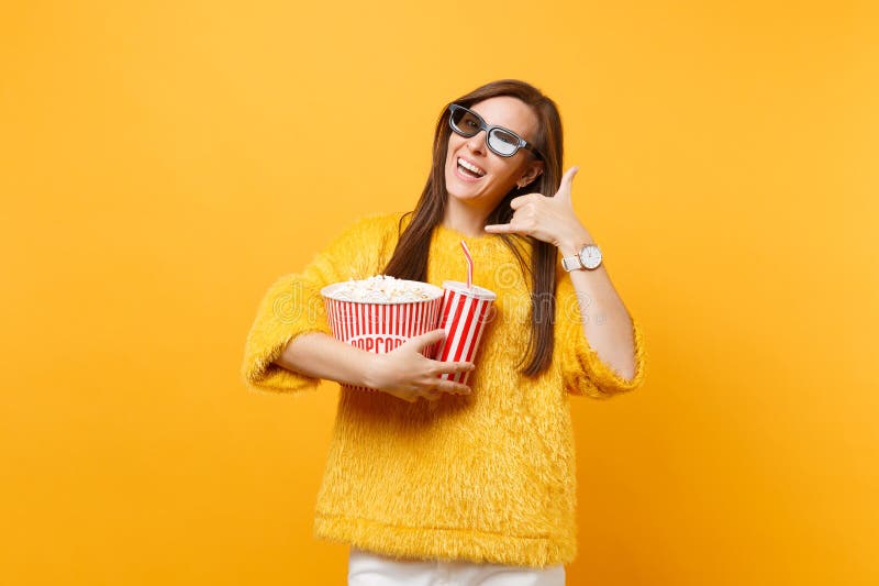 Женщина в стеклах imax 3d смотря фильм фильма в кино держа чашку попкорна соды делая жест телефона как говорит: звонок стоковое изображение rf Женщина в стеклах imax 3d смотря фильм фильма в кино держа чашку попкорна соды делая жест телефона как говорит: звонок стоковое изображение rf