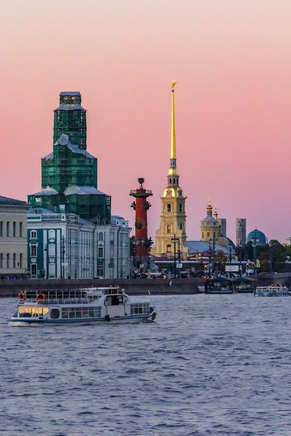 Заход солнца в Санкт-Петербурге над рекой Neva с взглядом обваловки дворца и шпиля крепости Питер и Пол стоковая фотография rf Заход солнца в Санкт-Петербурге над рекой Neva с взглядом обваловки дворца и шпиля крепости Питер и Пол стоковая фотография rf