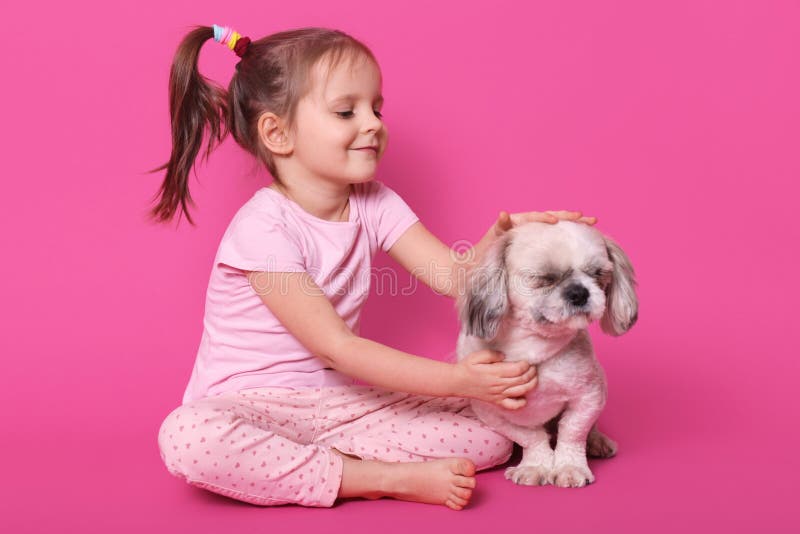 Любимцы маленькой девочки ее pekingese промежуток времени сидя с пересеченными ногами на поле Прелестный ребенок любит ее любимец стоковое фото Любимцы маленькой девочки ее pekingese промежуток времени сидя с пересеченными ногами на поле Прелестный ребенок любит ее любимец стоковое фото