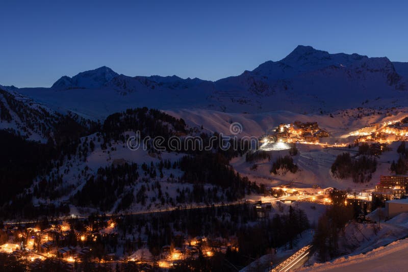 Лыжный курорт Plagne Ла во французской савойя Альп на сумерках в зиме Взгляд снега покрыл горы и здания стоковые изображения Лыжный курорт Plagne Ла во французской савойя Альп на сумерках в зиме Взгляд снега покрыл горы и здания стоковые изображения