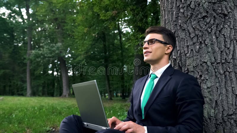 Молодой бизнесмен наслаждаясь работой в концепции природы, свободы и воодушевленности стоковые изображения rf Молодой бизнесмен наслаждаясь работой в концепции природы, свободы и воодушевленности стоковые изображения rf