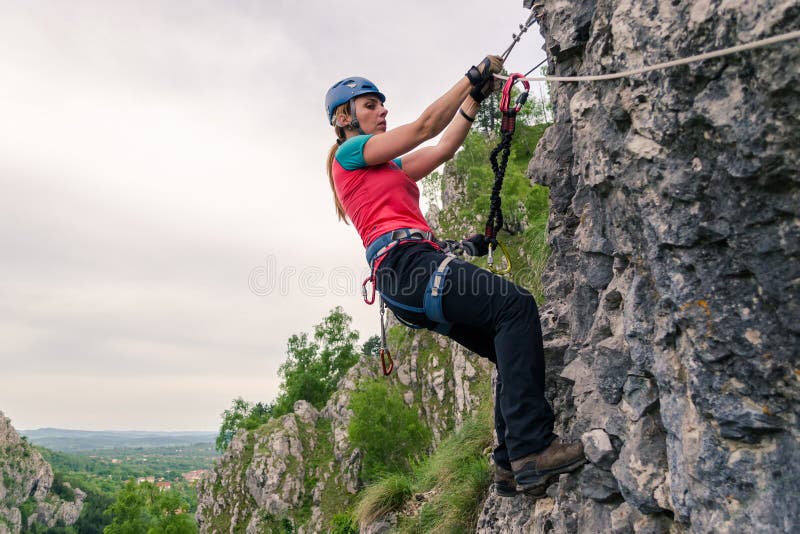 Молодая женщина вися от a через кабель ferrata, пока проходящ трудный раздел, оборудованный со шлемом, проводка, набор стоковые изображения rf Молодая женщина вися от a через кабель ferrata, пока проходящ трудный раздел, оборудованный со шлемом, проводка, набор стоковые изображения rf