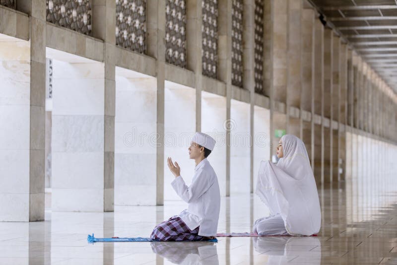 Молодая пара молит к Аллаху после делать Salat стоковые фото Молодая пара молит к Аллаху после делать Salat стоковые фото
