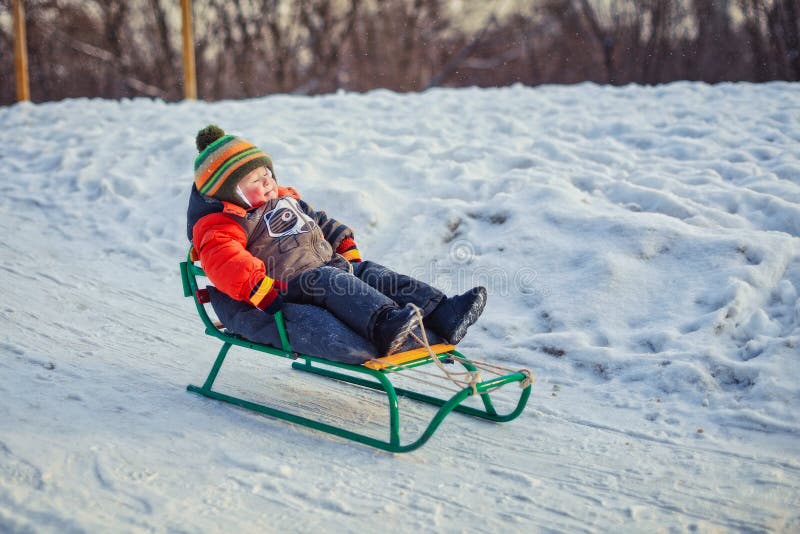 Мальчик наслаждаясь ездой саней Дети ехать розвальни Детская игра outdoors в снеге Ягнит скелетон в парке зимы стоковое изображение Мальчик наслаждаясь ездой саней Дети ехать розвальни Детская игра outdoors в снеге Ягнит скелетон в парке зимы стоковое изображение