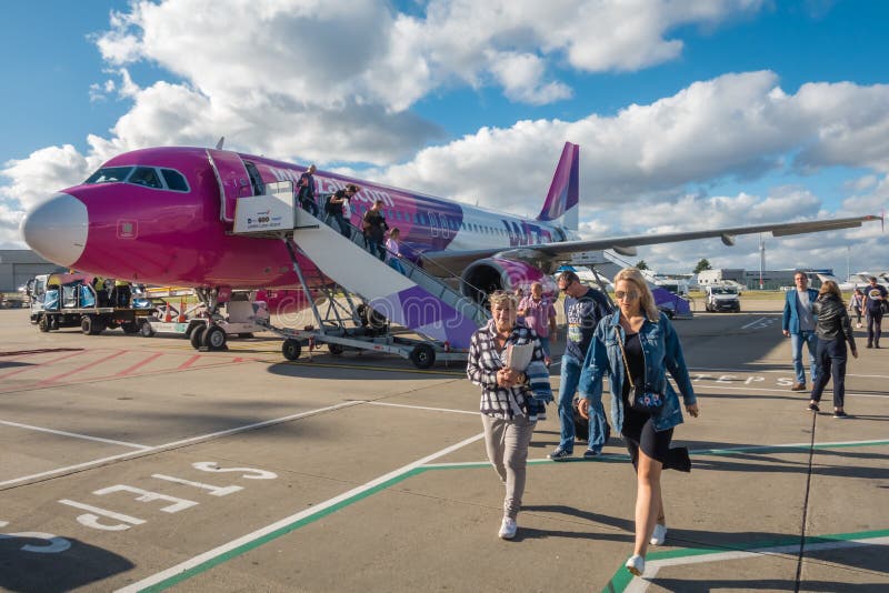 Пассажиры выходя самолет WizzAir стоковая фотография Пассажиры выходя самолет WizzAir стоковая фотография