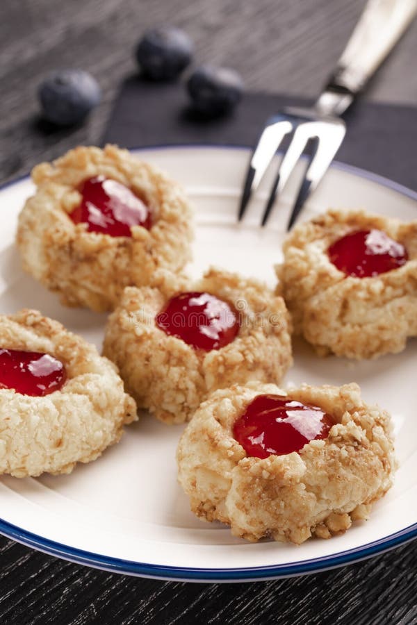Печенья сделанные из shortcake фундука с внутренностью варенья клубники на белой плите с голубиками стоковая фотография rf Печенья сделанные из shortcake фундука с внутренностью варенья клубники на белой плите с голубиками стоковая фотография rf