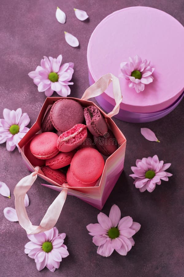 Пинк и пурпурный конец-вверх macaroon в бумажном мешке подарка на пурпурной предпосылке украшенной с цветками Взгляд сверху, селе стоковое фото rf Пинк и пурпурный конец-вверх macaroon в бумажном мешке подарка на пурпурной предпосылке украшенной с цветками Взгляд сверху, селе стоковое фото rf
