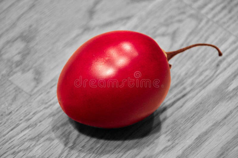 Плод Tamarillo на деревянной доске, покрасил черно-белый стоковое фото rf Плод Tamarillo на деревянной доске, покрасил черно-белый стоковое фото rf