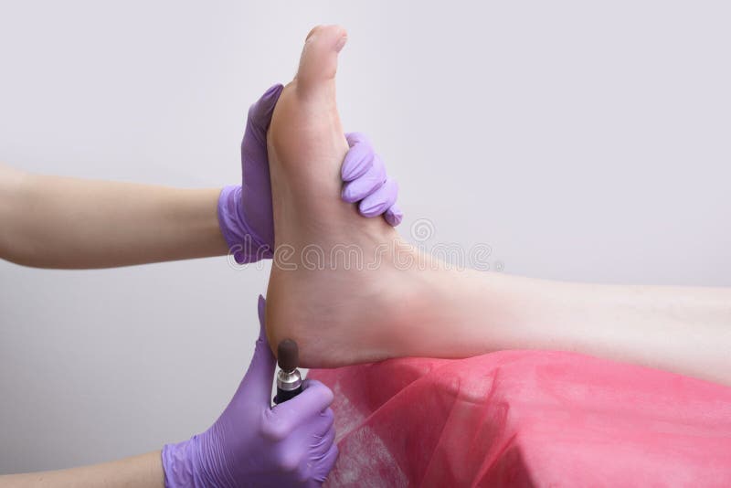Процесс обработки кожи ноги Gloved руки с машиной pedicure Конец-вверх стоковые фото Процесс обработки кожи ноги Gloved руки с машиной pedicure Конец-вверх стоковые фото