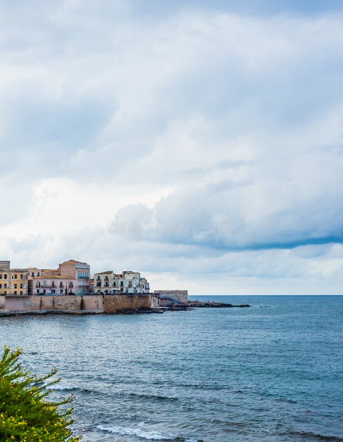 Прекрасный вид набережной Ortigia в Сиракузе на летний день, с голубыми морем и облачным небом как фон стоковые фотографии rf Прекрасный вид набережной Ortigia в Сиракузе на летний день, с голубыми морем и облачным небом как фон стоковые фотографии rf