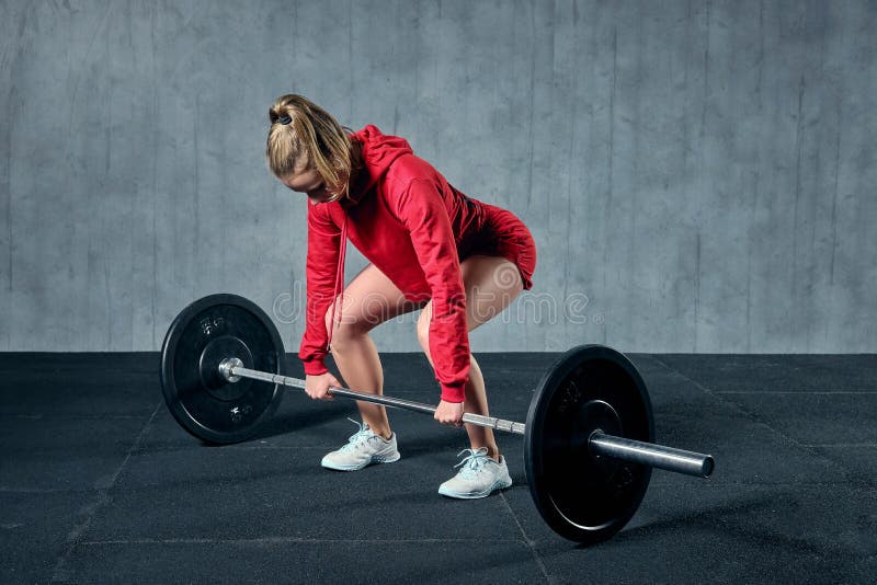Привлекательная молодая sporty женщина разрабатывает в спортзале Мышечная женщина сидит на корточках со штангой стоковое фото rf Привлекательная молодая sporty женщина разрабатывает в спортзале Мышечная женщина сидит на корточках со штангой стоковое фото rf