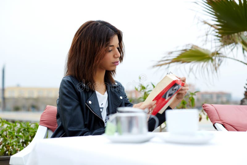 Сharming afro american woman reading novel or book during her recreation time at weekend stock photos Сharming afro american woman reading novel or book during her recreation time at weekend stock photos