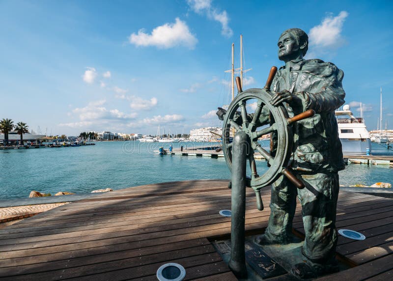 Статуя кормчия вдоль портового района Марины, Vilamoura, Алгарве, Португалии, Европы стоковая фотография rf Статуя кормчия вдоль портового района Марины, Vilamoura, Алгарве, Португалии, Европы стоковая фотография rf