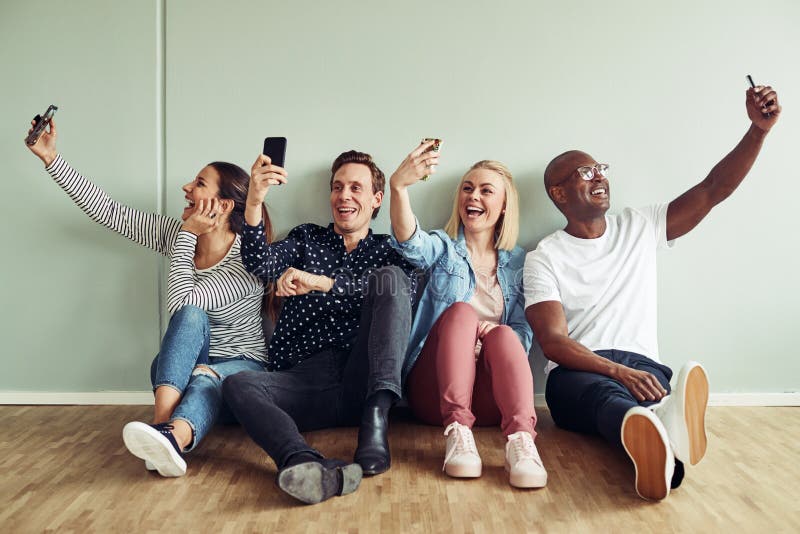 Усмехаясь молодые предприниматели принимая selfies во время их перерыва стоковое фото rf Усмехаясь молодые предприниматели принимая selfies во время их перерыва стоковое фото rf