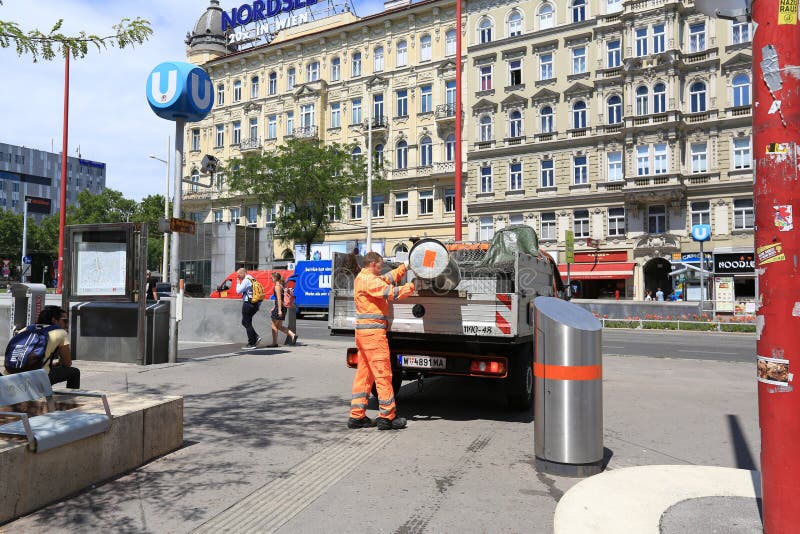 Работник в оранжевой форме опорожняет мусорный бак в мусоровоз Город вены, Австрии стоковое изображение rf Работник в оранжевой форме опорожняет мусорный бак в мусоровоз Город вены, Австрии стоковое изображение rf