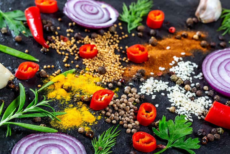 Различный вид специй и трав, chili, чеснока и лука на черной каменной предпосылке стоковые фотографии rf Различный вид специй и трав, chili, чеснока и лука на черной каменной предпосылке стоковые фотографии rf