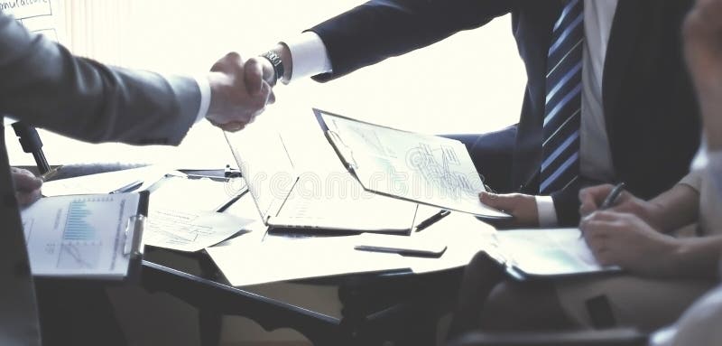 Рукопожатие старших деловых партнеров на столе стоковое изображение rf