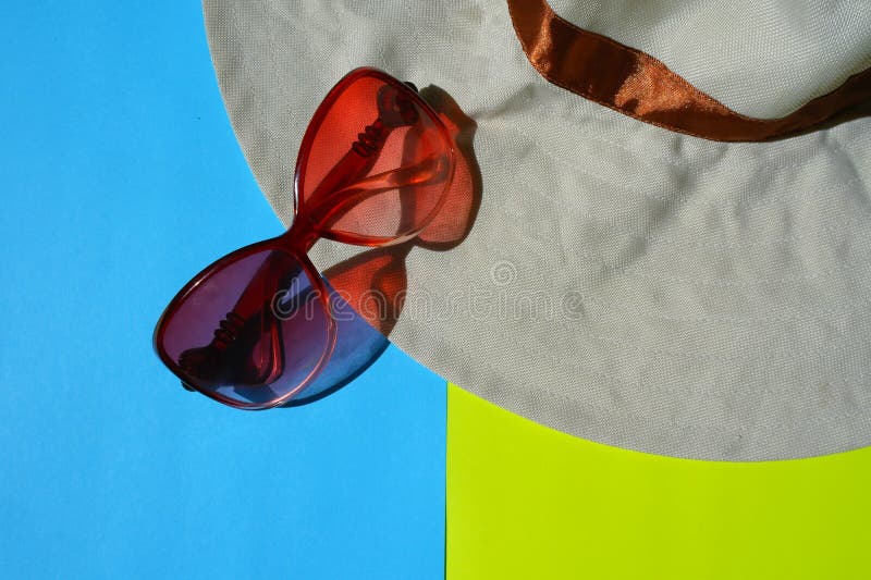Óculos de proteção de Sun, chapéu no fundo azul e amarelo foto de stock royalty free Óculos de proteção de Sun, chapéu no fundo azul e amarelo foto de stock royalty free