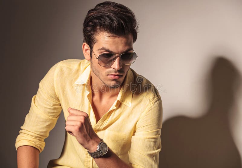 Óculos de sol vestindo do homem 'sexy' atrativo e camisa amarela imagem de stock Óculos de sol vestindo do homem 'sexy' atrativo e camisa amarela imagem de stock