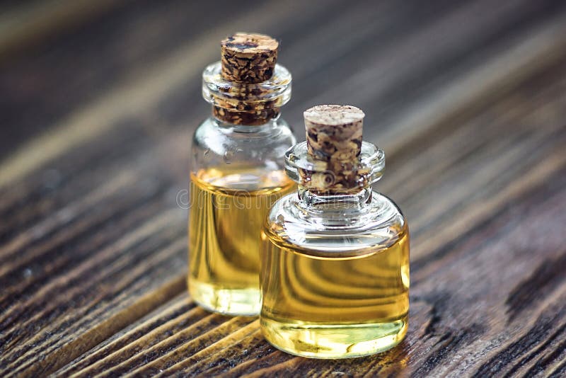 Óleo essencial do aroma orgânico puro na garrafa de vidro isolada no tratamento de madeira da beleza do fundo Bem-estar perfumado
