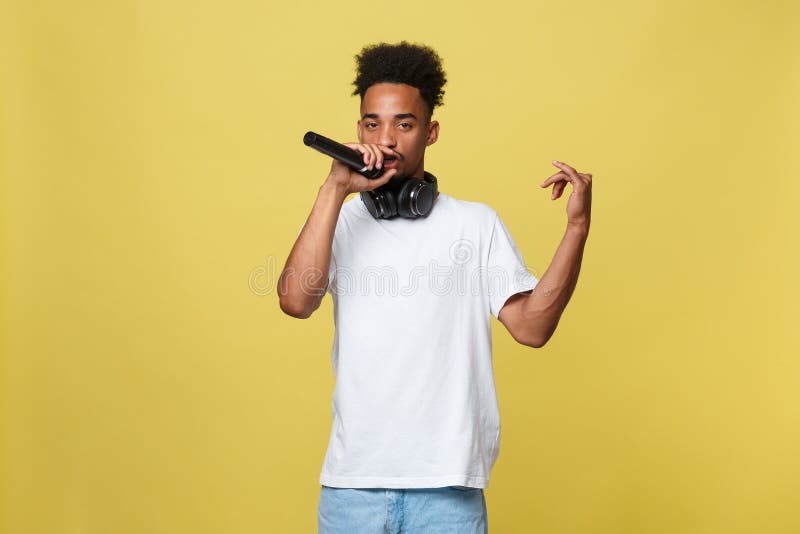 Ópera afroamericana hermosa joven del canto del muchacho emocional con el micrófono fotografía de archivo Ópera afroamericana hermosa joven del canto del muchacho emocional con el micrófono fotografía de archivo
