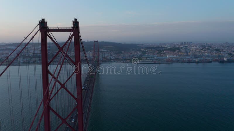 órbita aérea del gran ponte rojo 25 de abril bridge con tráfico de coches que atraviesa el mar en la costa de lisboa portugal almacen de video