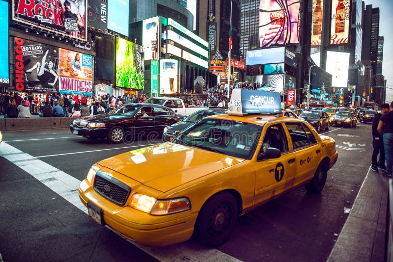 NEW YORK CITY - MAY 12: Yellow cab on Times Square traffic and animated LED signs, is a symbol of New York City and the United States, May 12, 2016 in Manhattan, New York City. USA. NEW YORK CITY - MAY 12: Yellow cab on Times Square traffic and animated LED signs, is a symbol of New York City and the United States, May 12, 2016 in Manhattan, New York City. USA.