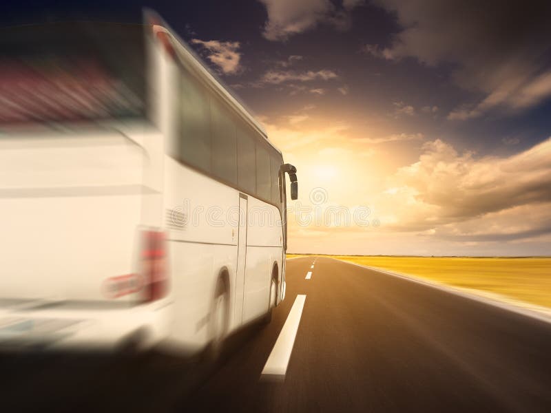 Ônibus branco na condução rápida em uma estrada asfaltada vazia fotografia de stock royalty free Ônibus branco na condução rápida em uma estrada asfaltada vazia fotografia de stock royalty free