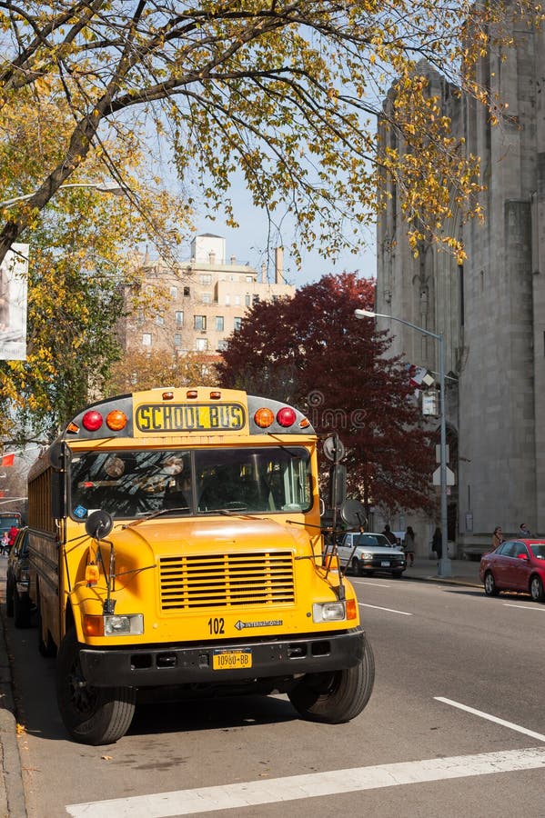 Ônibus escolar amarelo em uma rua de New York City no outono fotografia de stock Ônibus escolar amarelo em uma rua de New York City no outono fotografia de stock