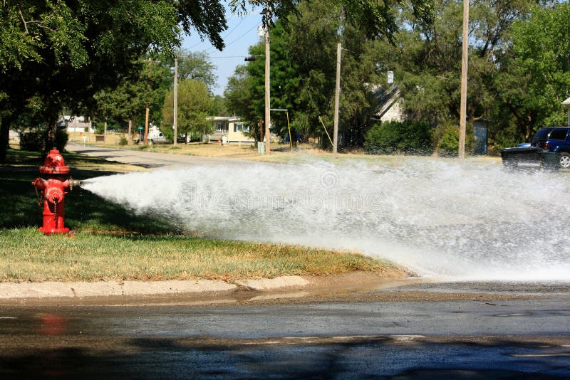 Öffnen Sie Feuer-Hydrant-strömendes Wasser in die Straße