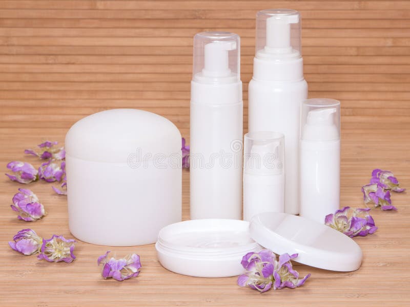 Öffnen Sie Glas Creme und andere Körperpflegekosmetik mit Blumen stockbild Öffnen Sie Glas Creme und andere Körperpflegekosmetik mit Blumen stockbild