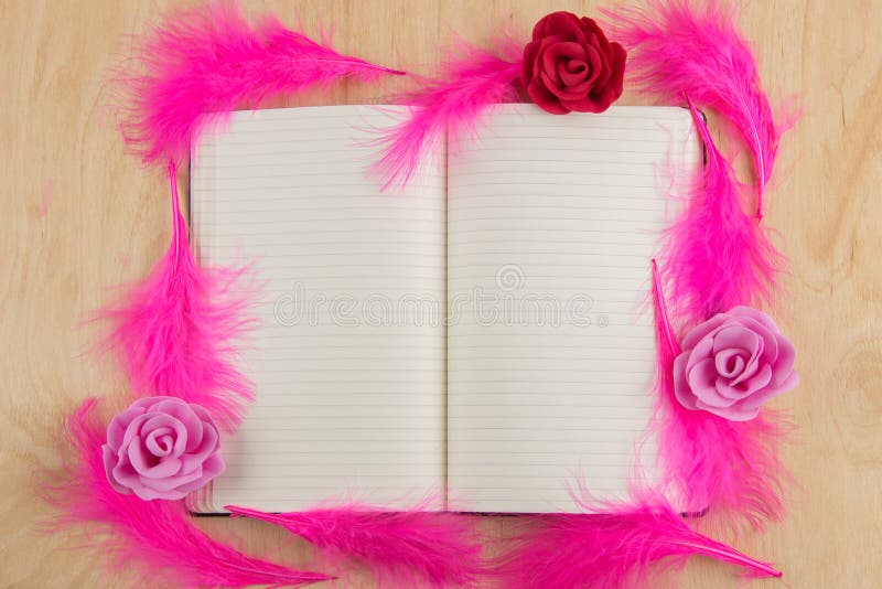Öffnen Sie Notizbuch mit white pages und rosa Federn auf einem hölzernen Vorsprung stockfoto Öffnen Sie Notizbuch mit white pages und rosa Federn auf einem hölzernen Vorsprung stockfoto