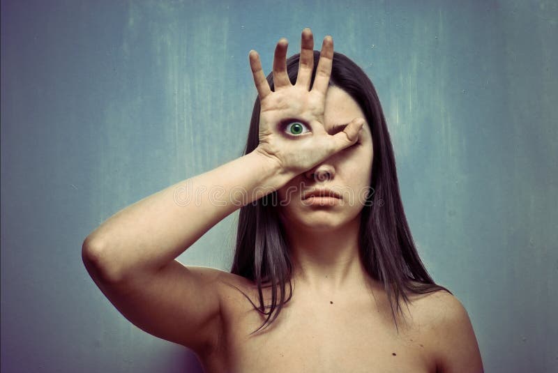 Studio portrait of young woman with eye on a palm. Studio portrait of young woman with eye on a palm