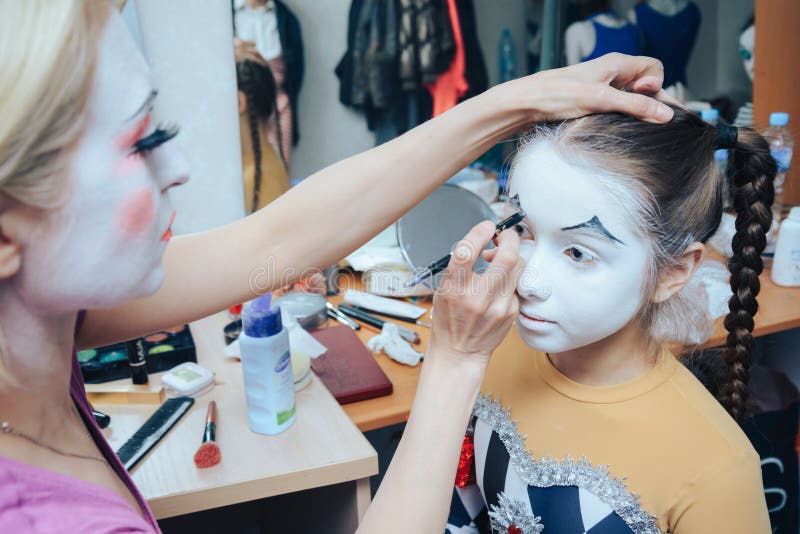 ögonblicket av att applicera clownmakeup till lite flickan royaltyfri foto ögonblicket av att applicera clownmakeup till lite flickan royaltyfri foto