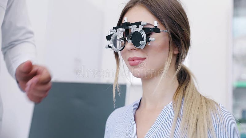 Ögonexamen Kvinna i exponeringsglas som kontrollerar synförmåga på kliniken