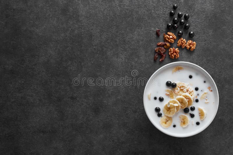 Över natten havre med över huvudet sikt för banan och för blåbär Den sunda frukosten mjölkar, blåbär, muttrar, russin, chiafrö oc royaltyfri foto Över natten havre med över huvudet sikt för banan och för blåbär Den sunda frukosten mjölkar, blåbär, muttrar, russin, chiafrö oc royaltyfri foto