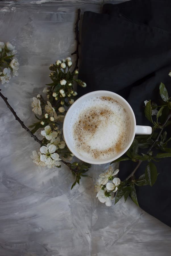 Överblick av den varma koppen kaffe med vita blommor arkivfoto Överblick av den varma koppen kaffe med vita blommor arkivfoto