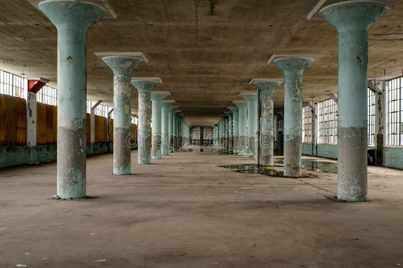 Övergav Teal Concrete Columns & stora Windows - bekläda fabriken royaltyfri fotografi
