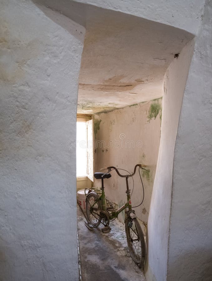Övergiven cykel inom ett eftersatt koniskt taklagt Trulli hus i Alberobello, Puglia Italien arkivbild