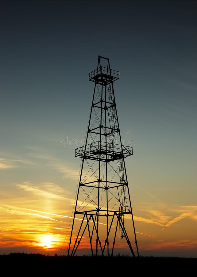 Övergiven oljebrunn vid solnedgång royaltyfri bild
