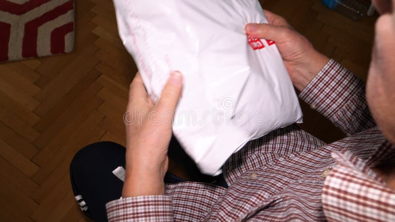 Överkänslig sikt av äldre personer som packar upp plasten ur förpackningen