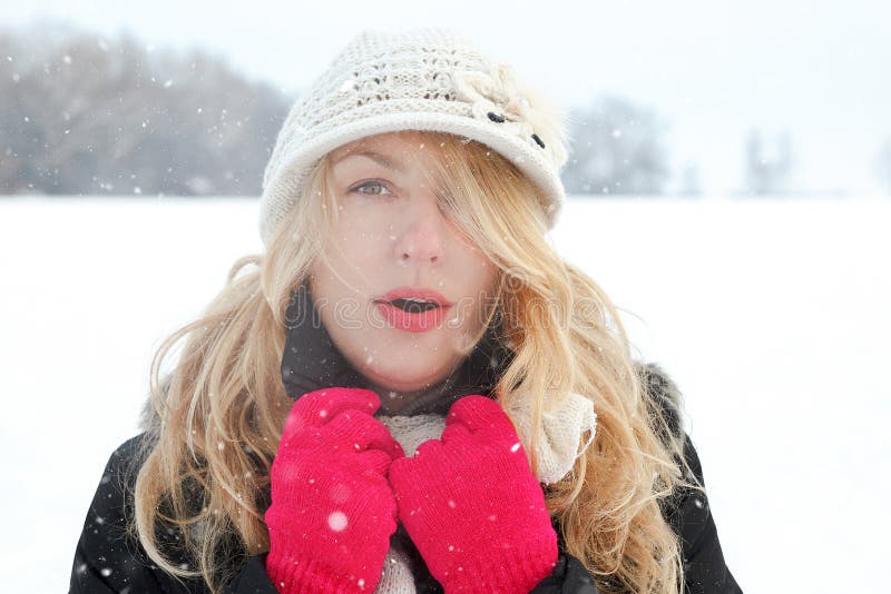 Övervintra kvinnan i snöfoto och att se och blåser andedräkt fotografering för bildbyråer Övervintra kvinnan i snöfoto och att se och blåser andedräkt fotografering för bildbyråer