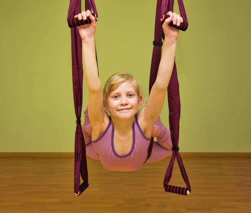 Övningar för yoga för liten flickadanande flyg-, inomhus arkivbilder Övningar för yoga för liten flickadanande flyg-, inomhus arkivbilder